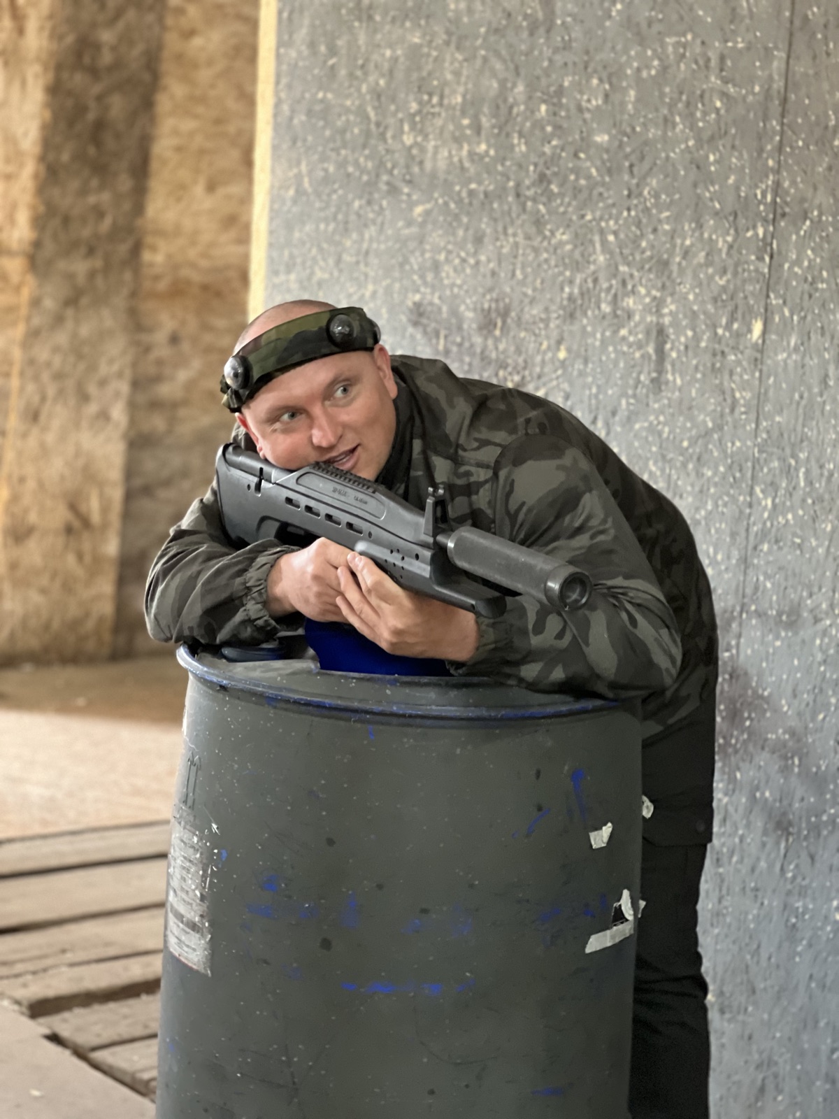 Инструктор с оружием у бочки на площадке